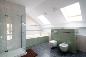 Modern bathroom with pale green tiles, large shower and bathtub.